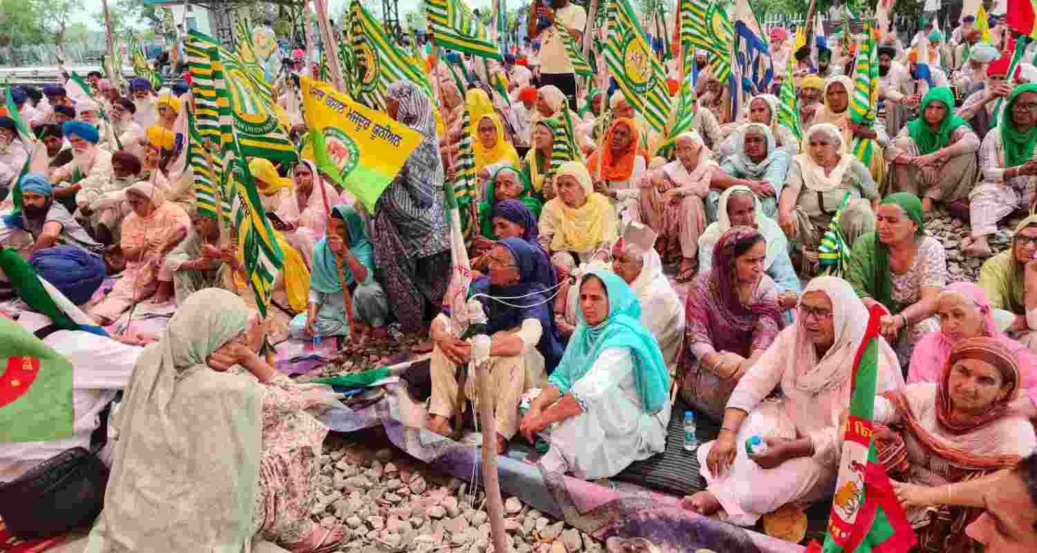 Farmers sitting on rails. 