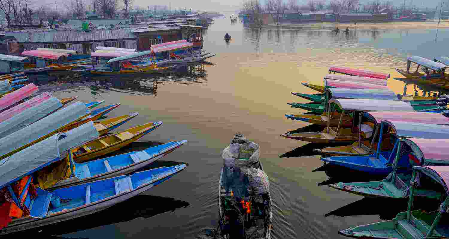 Workers light a bonfire on their boats to keep warm as the mercury plunges to minus 5.7 degrees Celsius during Chillai Kalan, the 40-day period of the harshest winter in the Kashmir Valley, at interior Dal Lake, in Srinagar, Saturday