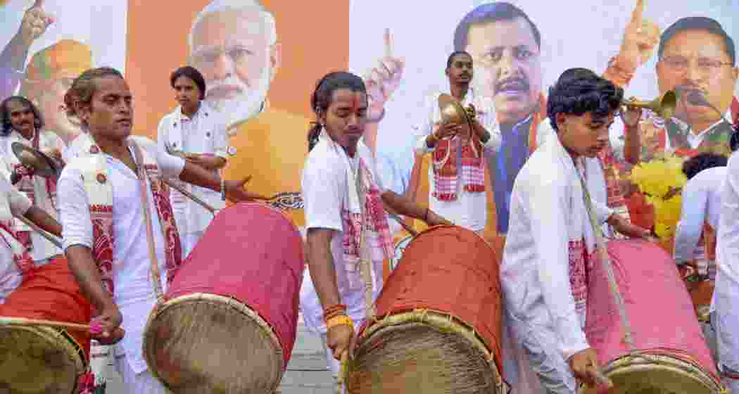 Artists play traditional drums as BJP workers celebrate the party taking lead during the Assam Assembly elections results day, at party headquarters, in Guwahati, on Monday.