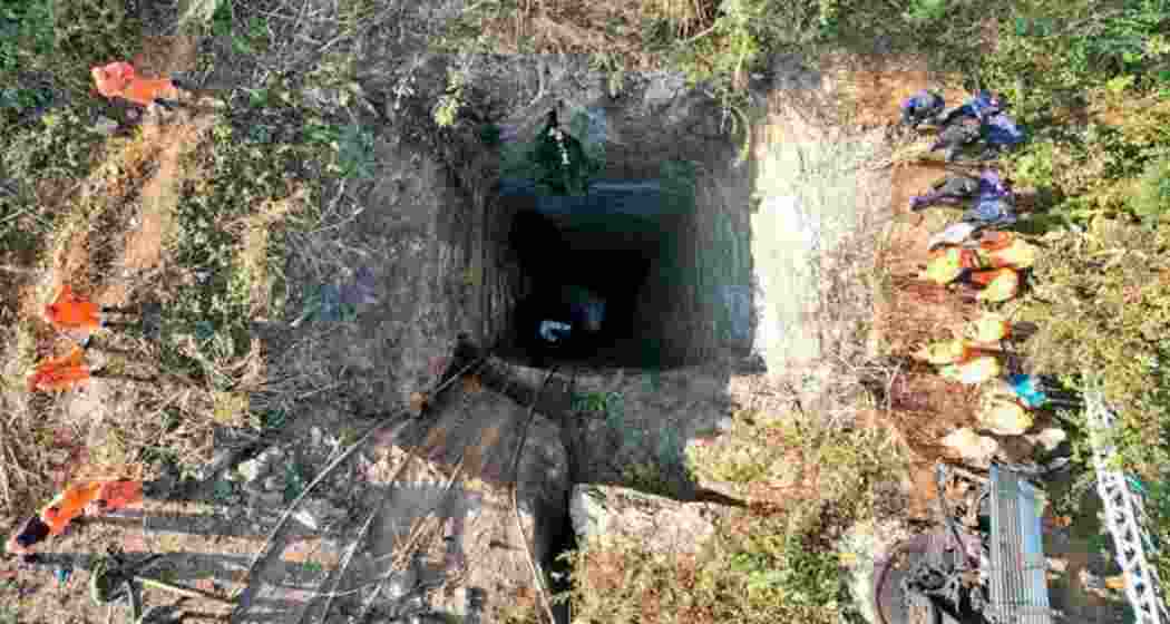 Rescue workers standing around the coal mine where at least nine workers were trapped in Assam. 