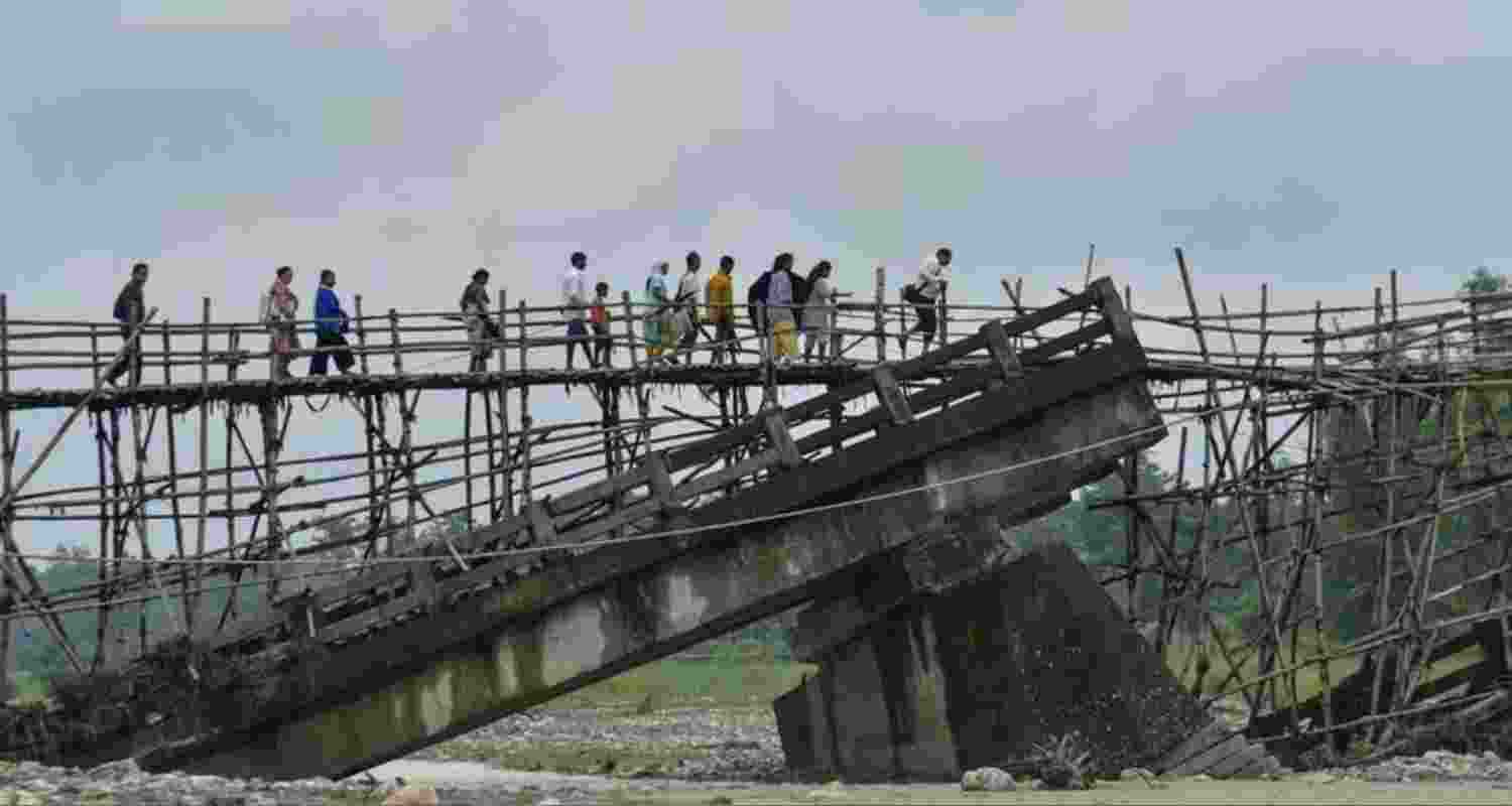 Villagers use a temporary bamboo bridge to cross a river after the RCC bridge over it washed away in flood water in Baksa district. Villagers use a temporary bamboo bridge to cross a river after the RCC bridge over it washed away in flood water in Baksa district.