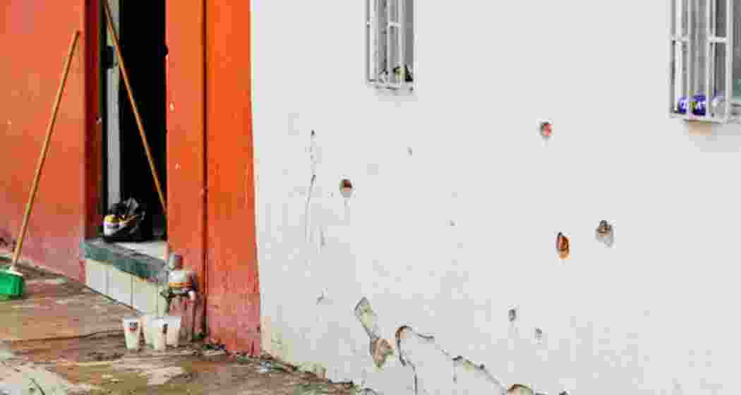 Votive candles are placed near the bullet-riddled house where gunmen opened fire on Tuesday during a party celebrating the Nativity of John the Baptist. 