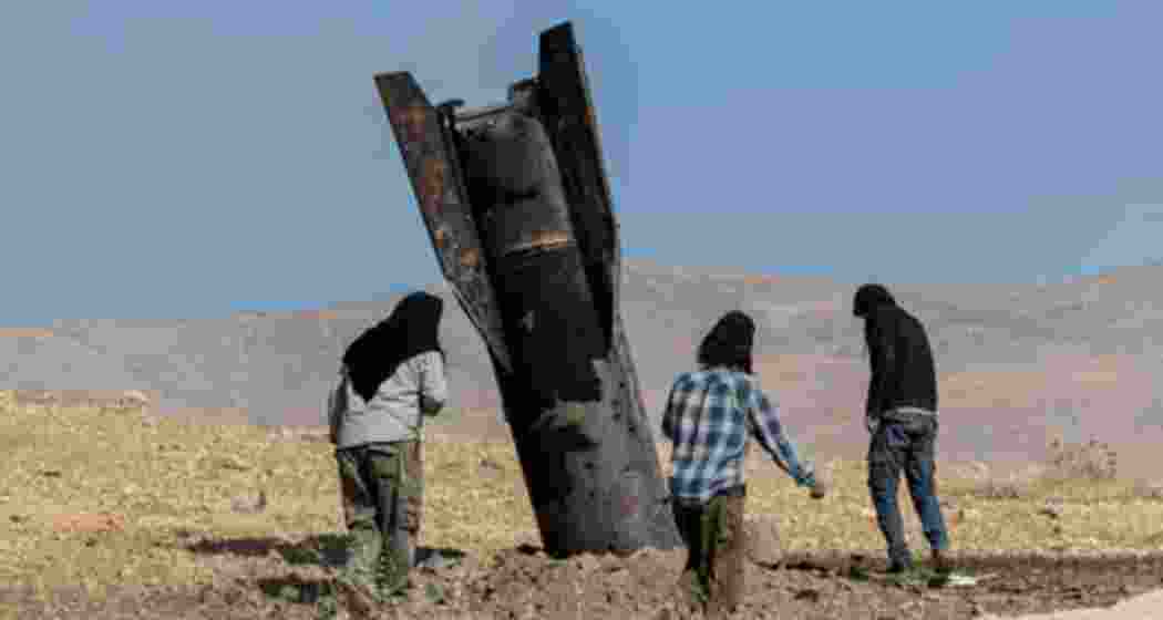 People stand next to part of a missile protruding from the ground, following strikes from Iran, in the central West Bank, 8 June, 2026. Photograph: Naama Stern/Reuters.