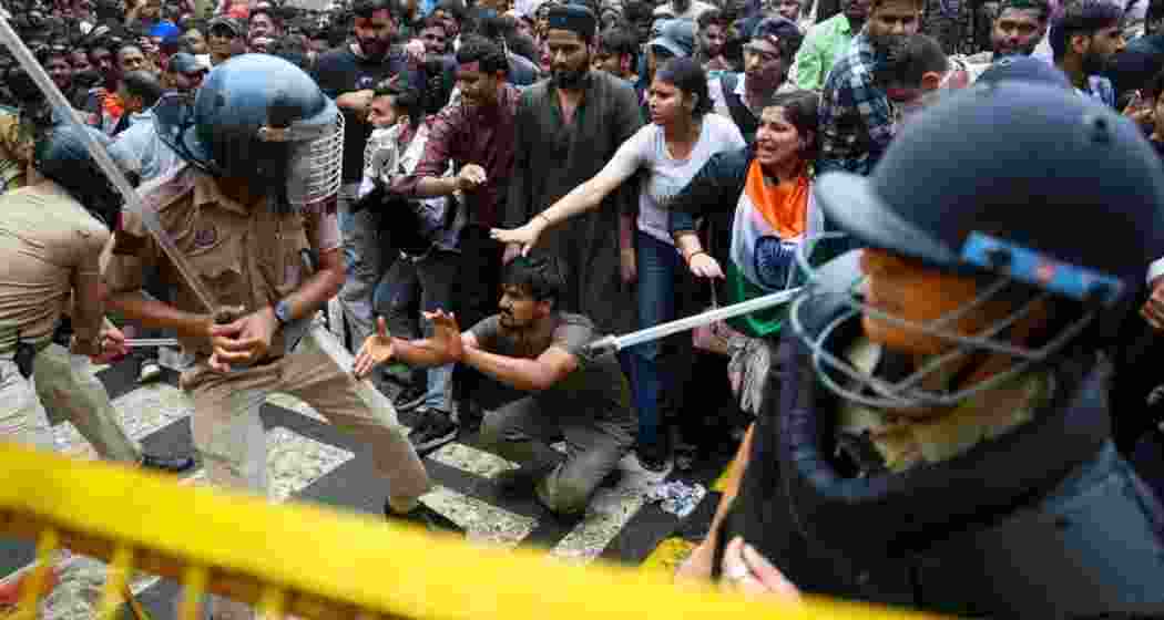 Police personnel confront CJP supporters during a protest near a barricade in New Delhi.