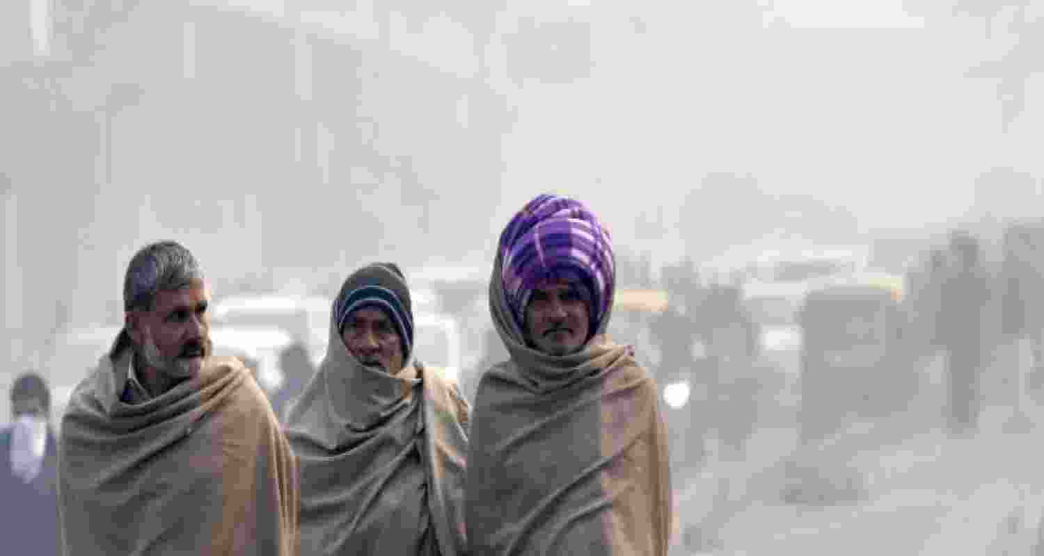 Commuters brave the morning chill and fog at Dwarka, in New Delhi.