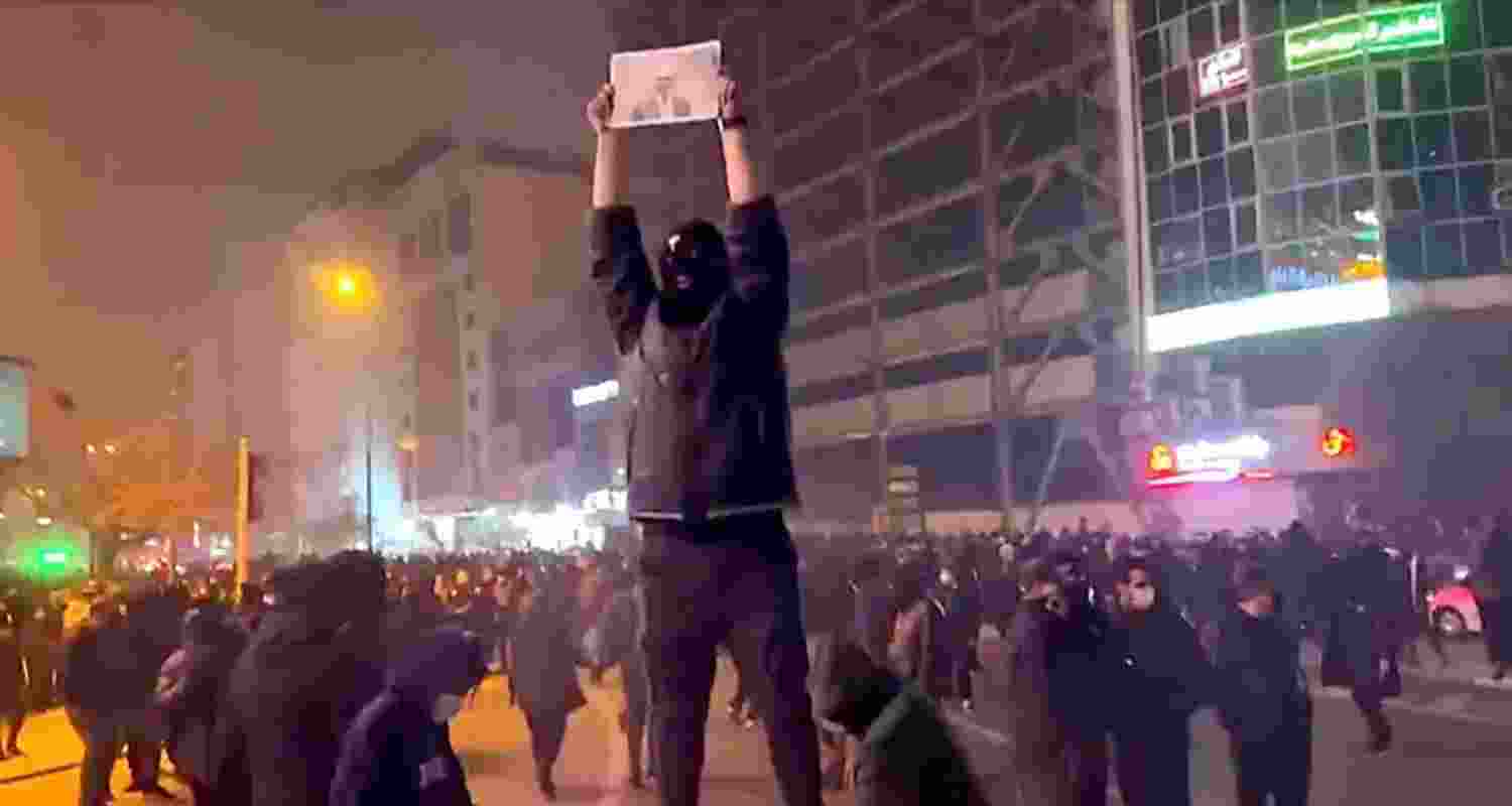 A protester holding up a picture of crown prince Reza Pahlavi at Kaj Square in north-western Tehran on Friday.