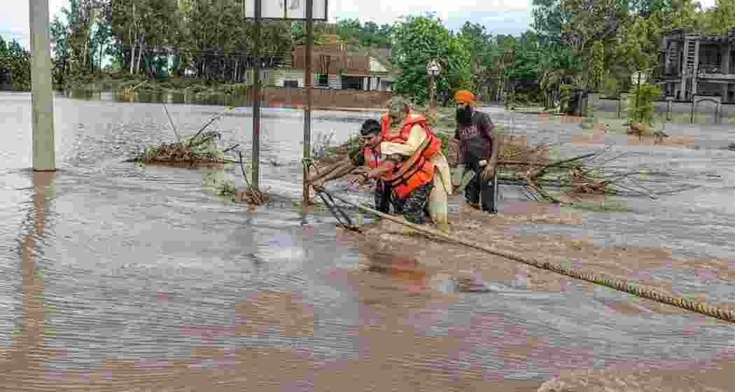 An NDRF official rescuing an elderly man in a village of Fazilka district. (File photo) An NDRF official rescuing an elderly man in a village of Fazilka district. (File photo)
