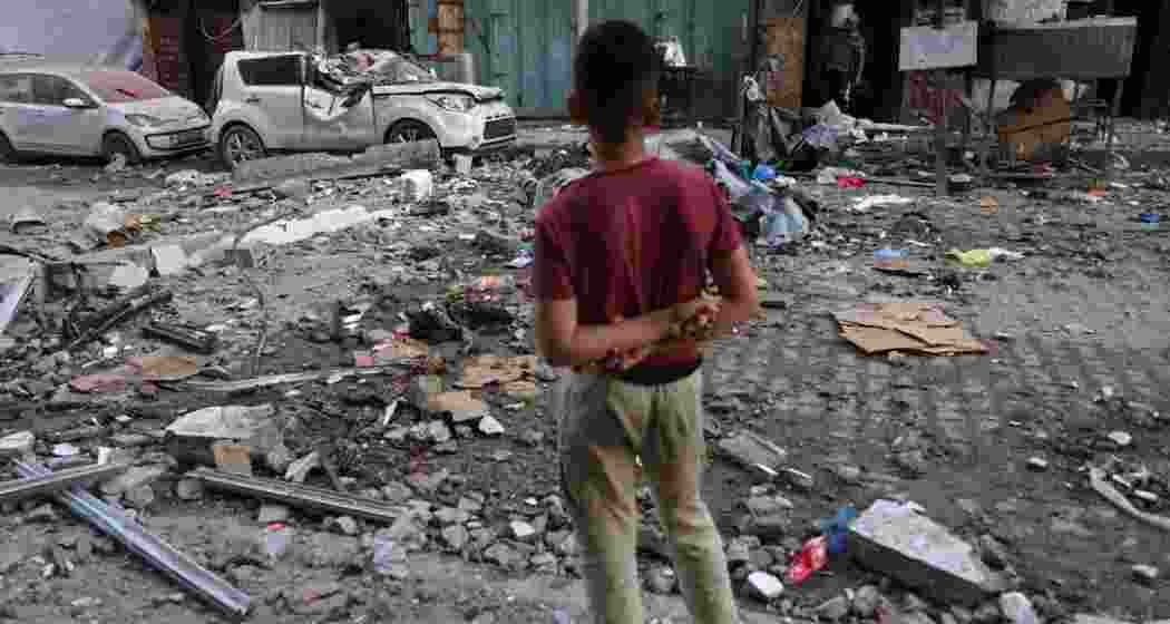 A Palestinian boy looking at the rubble in the aftermath of an Israeli strike in Gaza City.