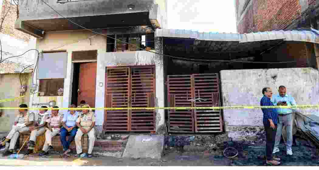 Police officials at the site after a fire broke out in a factory operated in a small house in Jaipur's Kho-Nagorian area on Tuesday.