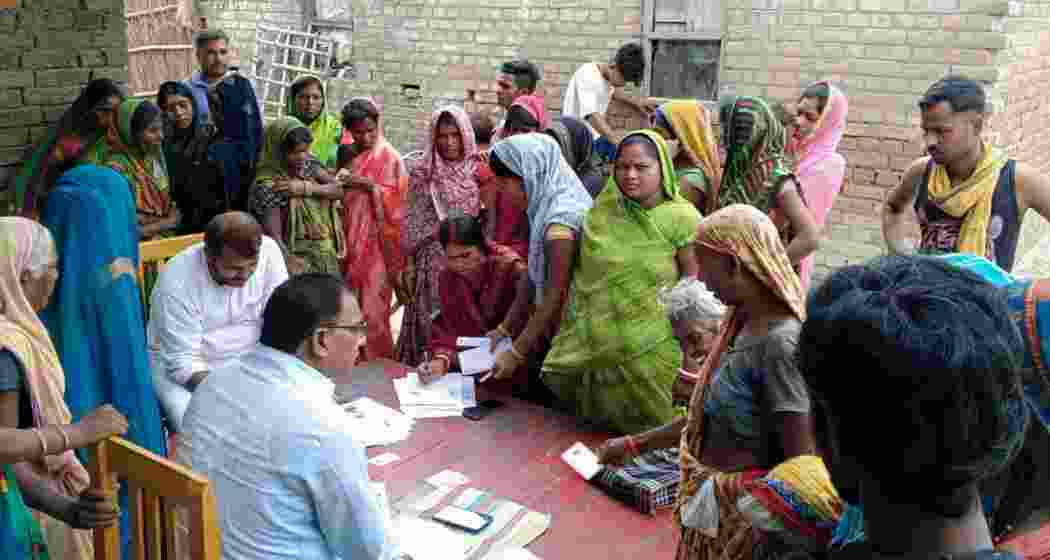 Election officials collect enumeration forms during the Special Intensive Revision of electoral rolls.