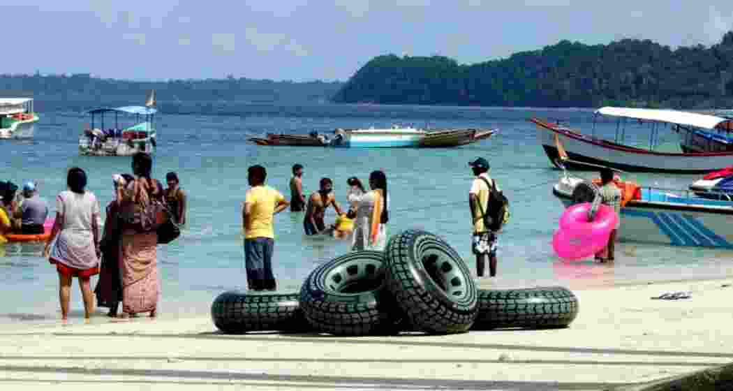 Tourists enjoying the sea waves at Elephant Beach, in the Andaman and Nicobar Islands.