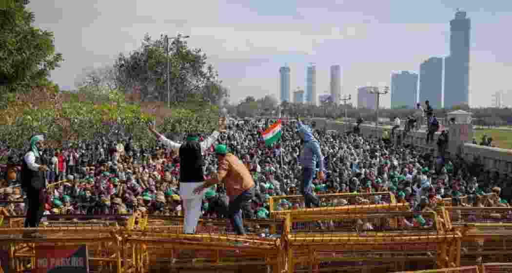 Farmers climb a police barricade during a protest demanding a hike in land compensation and better rehabilitation facilities for their families, in Noida on the outskirts of New Delhi. Farmers climb a police barricade during a protest demanding a hike in land compensation and better rehabilitation facilities for their families, in Noida on the outskirts of New Delhi.