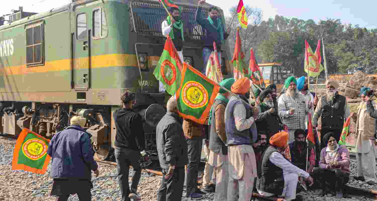 Farmers block railway tracks as part of their state-wide 'Rail Roko' protest to press the Centre into accepting their various demands, including a legally binding minimum support price for crops, in Patiala, Punjab, Wednesday. 
