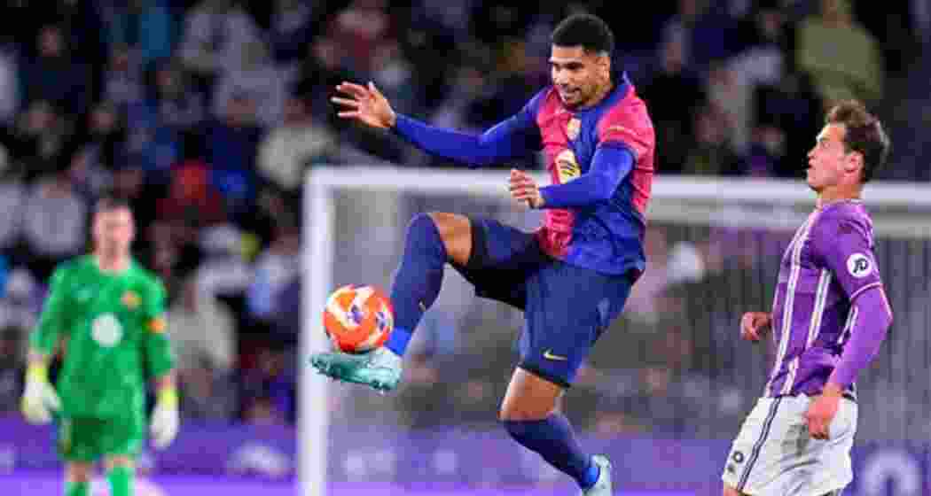 Barcelona's Ronald Araujo, centre, and Valladolid's Juanmi Latasa challenge for the ball during the Spanish La Liga soccer match between Valladolid and FC Barcelona at the Jose Zorrilla stadium in Valladolid, Spain, Saturday, May 3, 2025.
