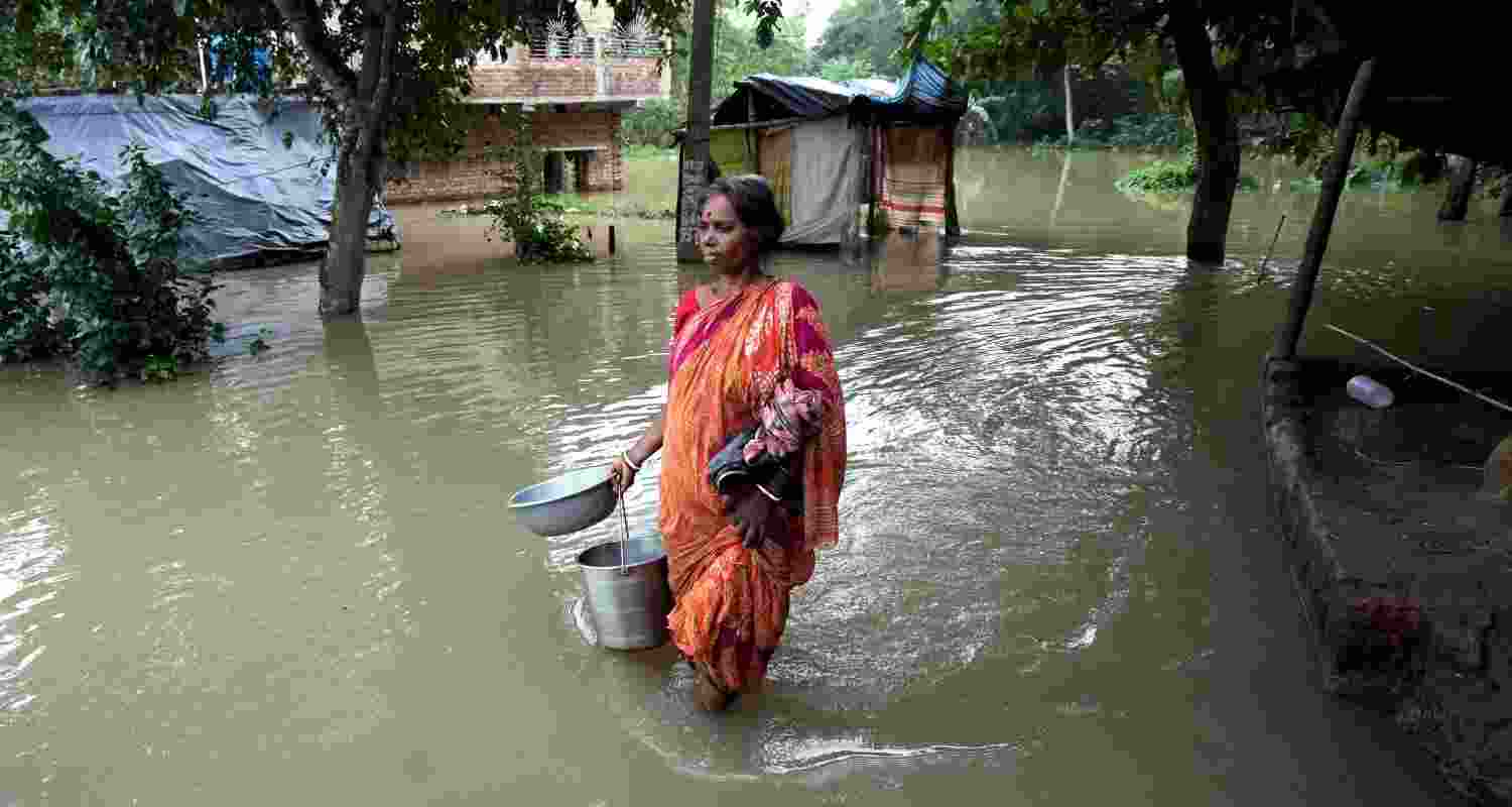 A woman traverses through floodwaters in West Bengal. A woman traverses through floodwaters in West Bengal.