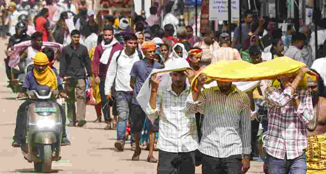 People walk amidst severe heatwave conditions on a hot summer day, in Varanasi, on Wednesday.