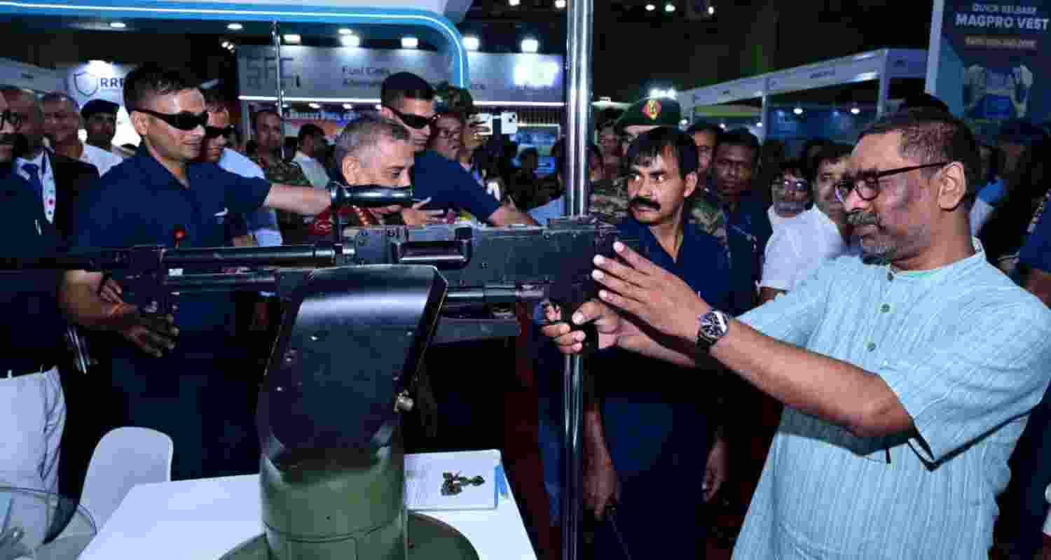 Jharkhand Chief Minister Hemant Soren holds an automatic weapon at the East Tech Symposium 2025 in Ranchi on Friday. 