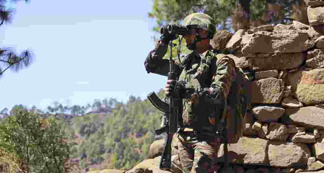 An Indian Army soldier monitors the Line of Control (LoC) through binoculars in the Krishna Ghati sector of Poonch, Jammu and Kashmir, on Wednesday, following an infiltration attempt by Pakistani forces on Tuesday.