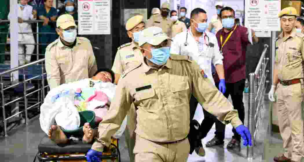  Security pesonnel wheel a patient on a stretcher during the transfer of three Kuki youths from the Regional Institute of Medical Sciences (RIMS), in Imphal, Manipur, on Wednesday,