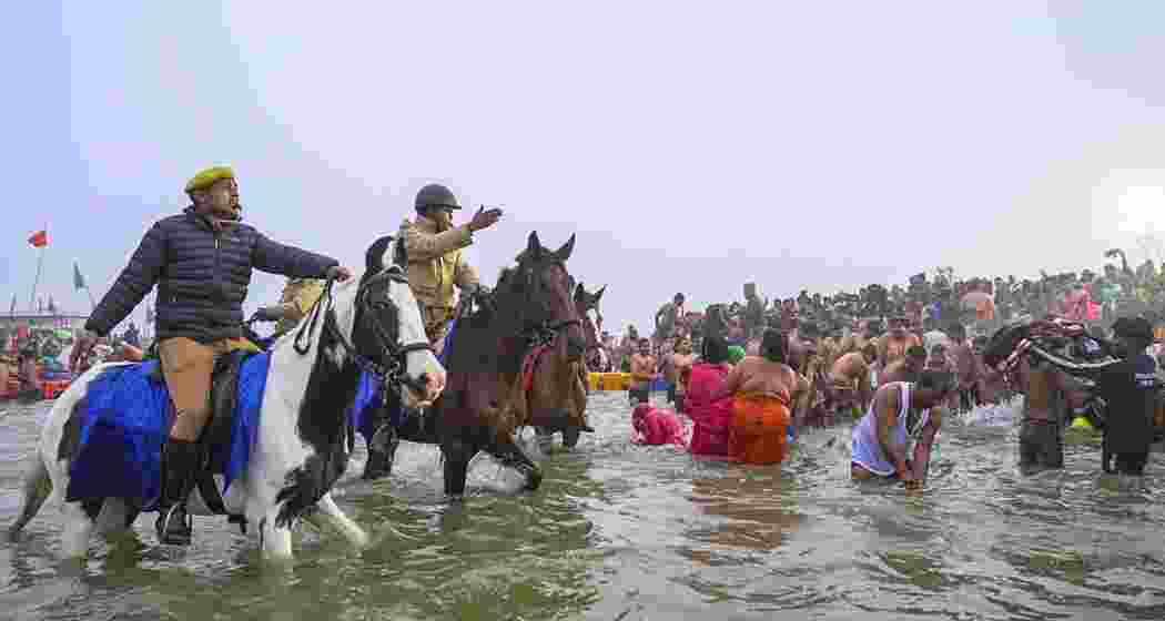 Security personnel try to manage a rush of devotees who arrive to take a holy dip at the Sangam on the 'Makar Sankranti' festival, during the Mahakumbh Mela, in Prayagraj on Tuesday, Jan. 14, 2025.