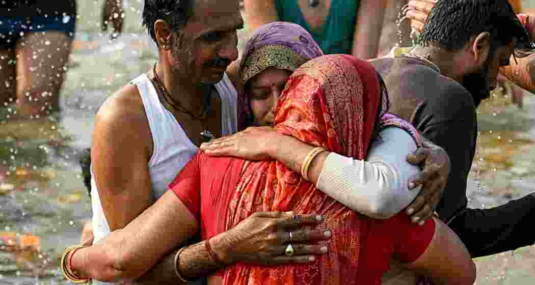 A man embraces his family after reuniting during the Mahakumbh 2025 in Prayagraj, an event that facilitated over 54,000 reunions with the help of AI technology.