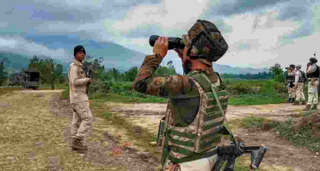 Security forces patrol villages in Manipur’s Ukhrul district after a pre-dawn attack, with one personnel scanning the area through binoculars following the killing of three in the region. 