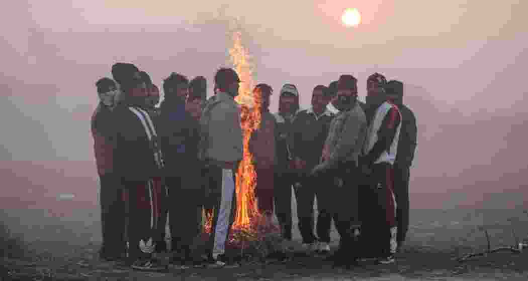 People on the outskirts of Delhi gather around a bonfire for warmth and togetherness.