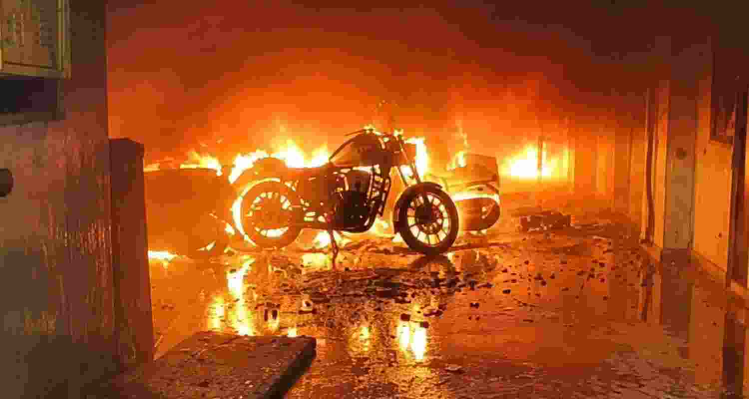 Two people died after an EV being charged caught fire in a Noida building, triggering a blaze that spread to parked vehicles. Nearly 50 residents were rescued.