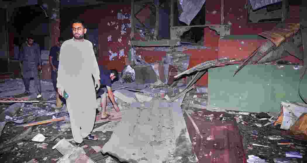Local residents inspect a building damaged in a suspected Indian missile strike near Muzaffarabad, the capital of Pakistan-controlled Kashmir, on May 7, 2025, following heightened military tensions between India and Pakistan.