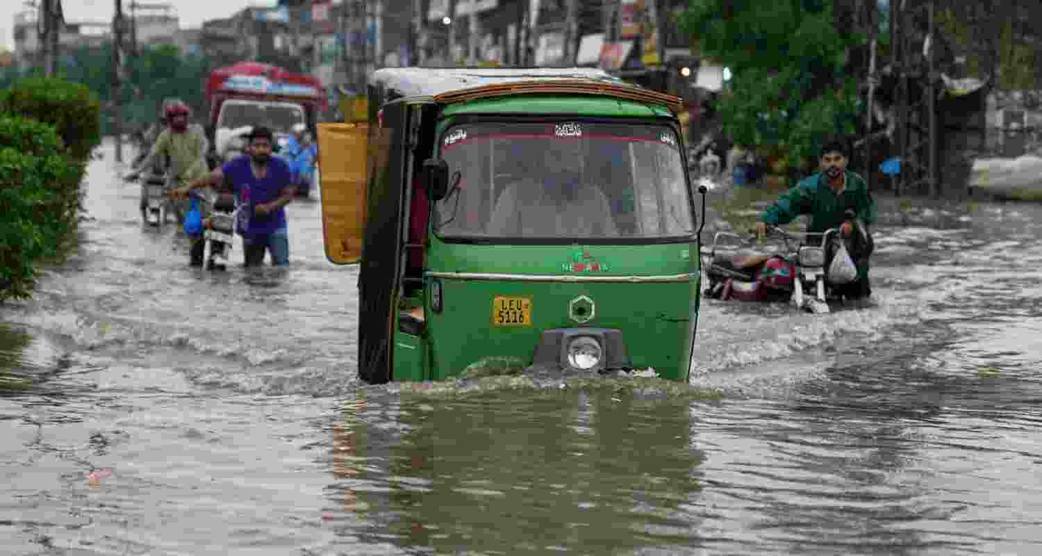 Motorists drive through a flooded road caused by heavy monsoon rain in Lahore, Pakistan.