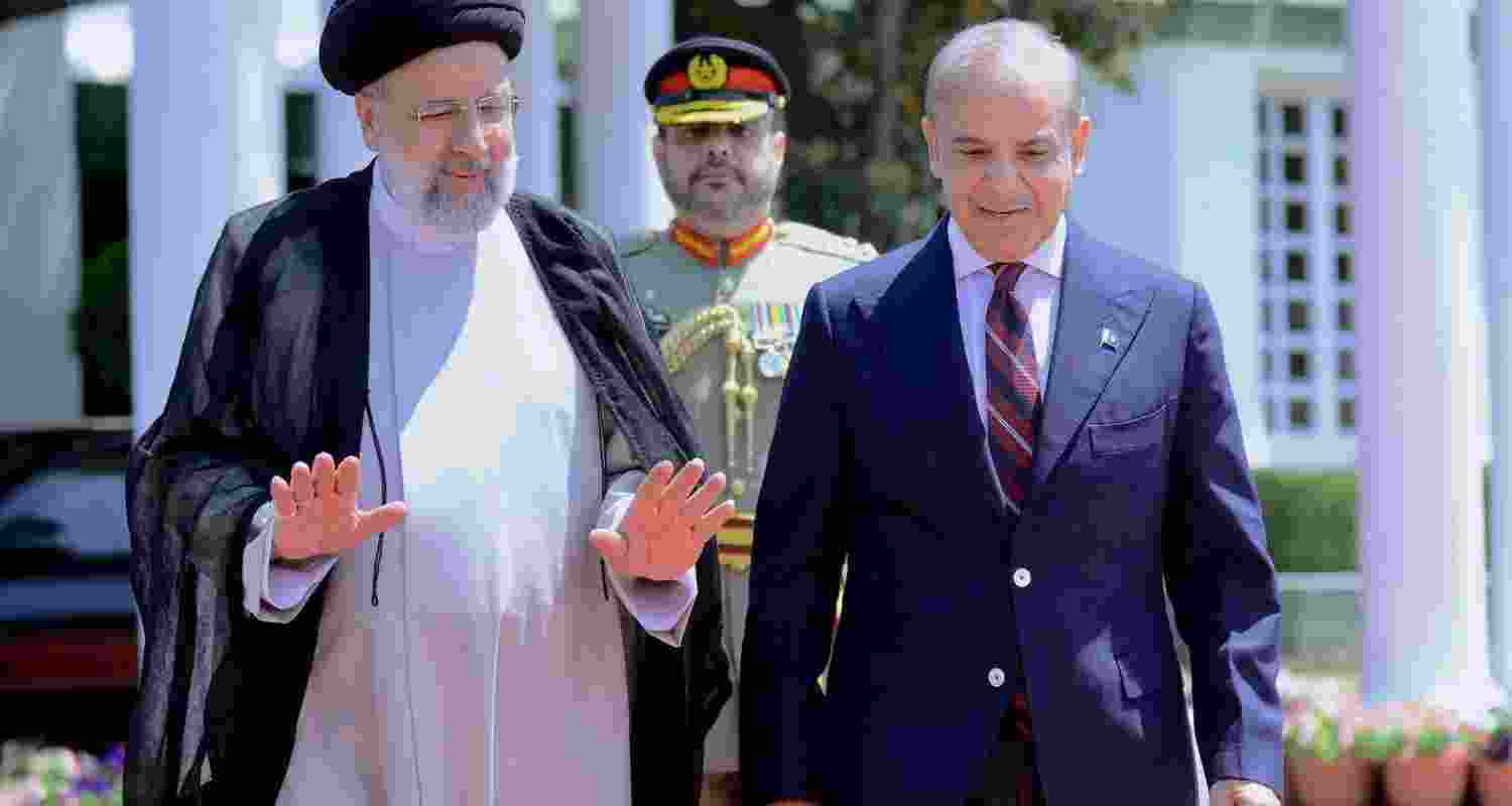Prime Minister Office, Iranian President Ebrahim Raisi, with Pakistan's Prime Minister Shehbaz Sharif, left, prays after planting a tree in the prime minister house in Islamabad, Pakistan.