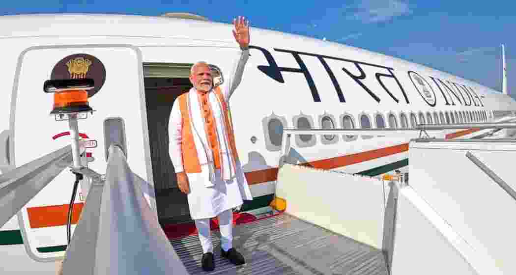 Narendra Modi waves before departing on an international tour. 