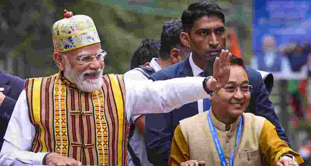 Prime Minister Narendra Modi waves during a roadshow, in Gangtok, Sikkim. State Chief Minister Prem Singh Tamang is also seen. (PMO via PTI Photo)