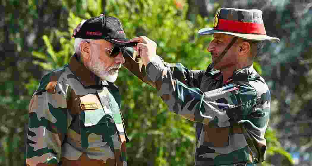 A soldier places a military cap on Prime Minister Narendra Modi during Diwali celebrations in Rajouri.
