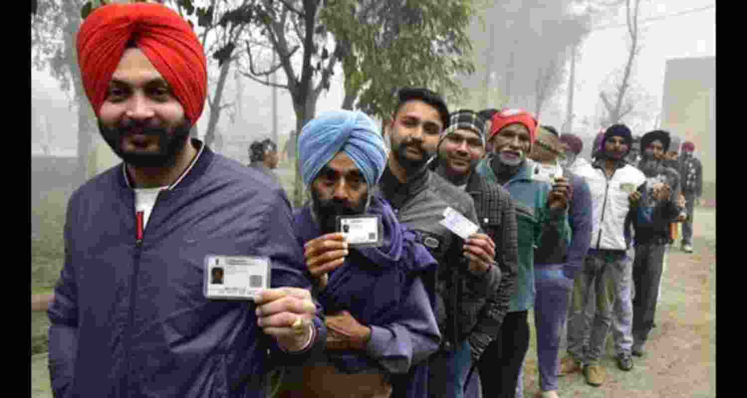 People standing in queue, waiting to cast their votes.