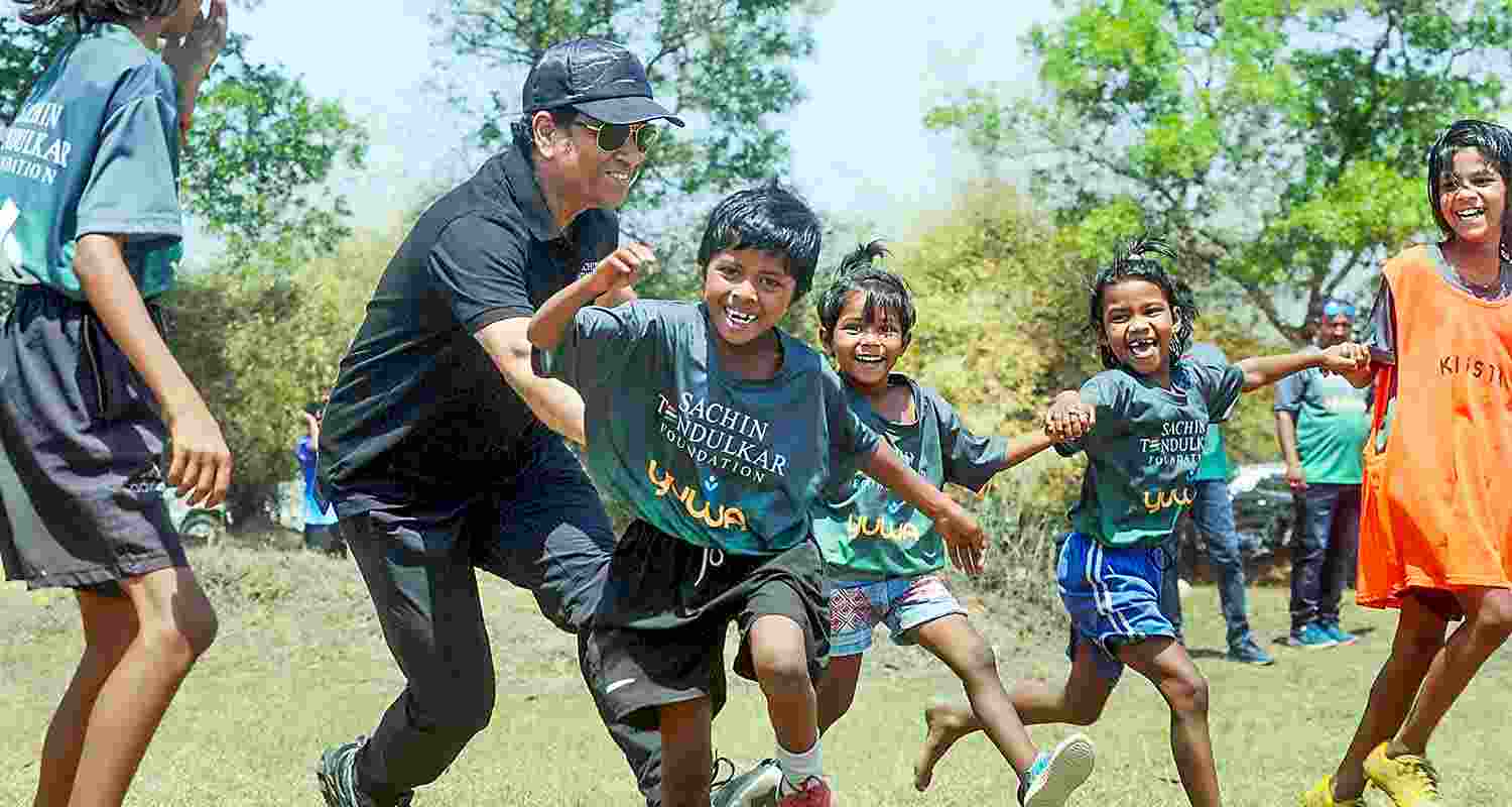 Former cricketer Sachin Tendulkar with wife Anjali Tendulkar pose for group photos with budding football players of Yuwa Foundation, in Ranchi