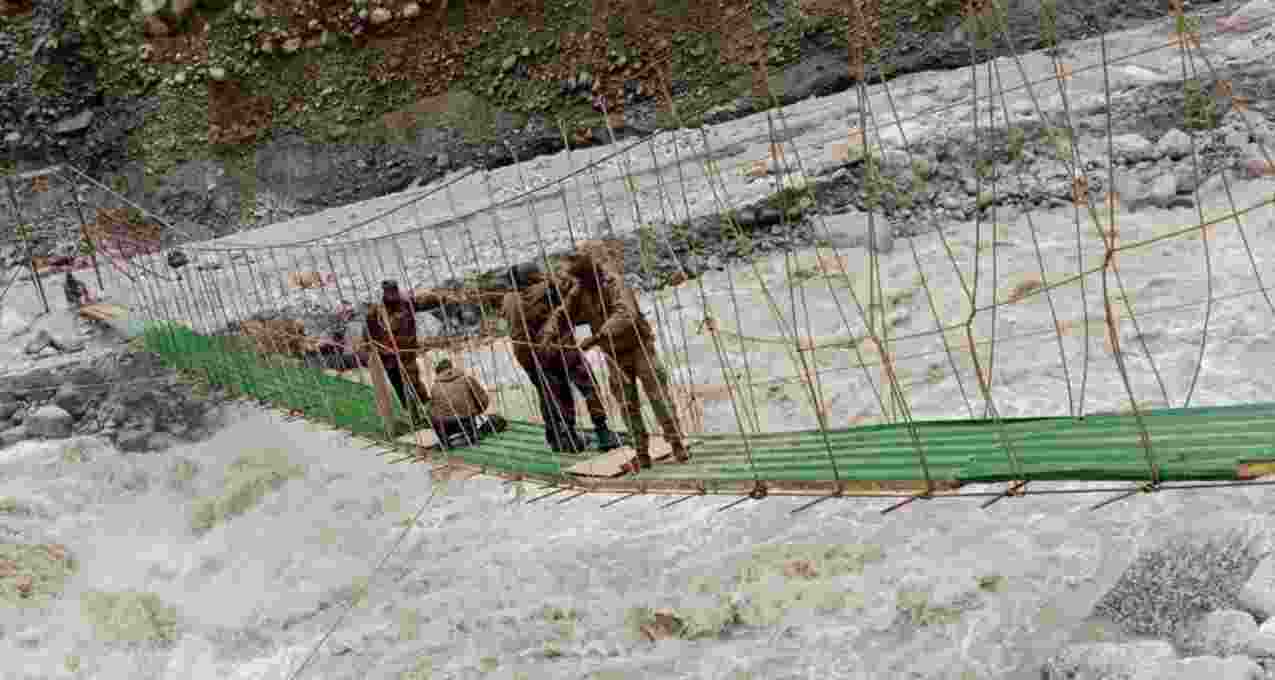 The 150-foot suspension bridge, being constructed by engineers of Indian Army, being given final touches under a fast flowing river. 