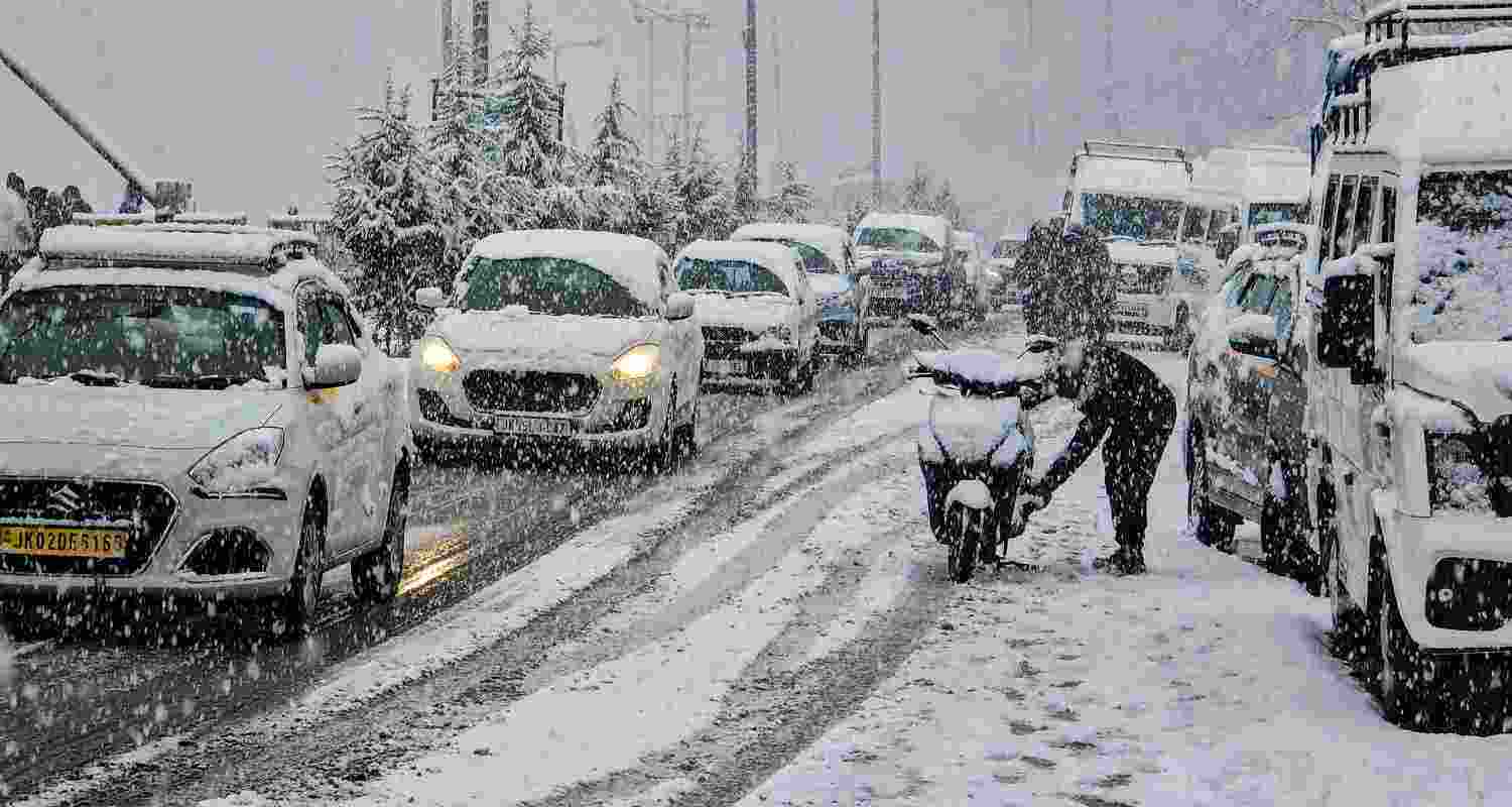  Vehicles ply on a road at Tangmarg amid fresh snowfall, in Baramulla district, Friday. 