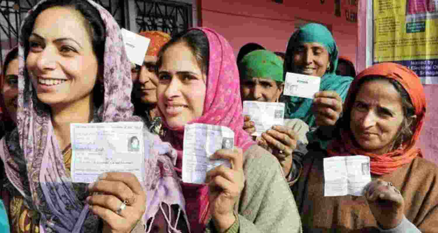 Women hold up their voter ID cards in Srinagar. Women hold up their voter ID cards in Srinagar.