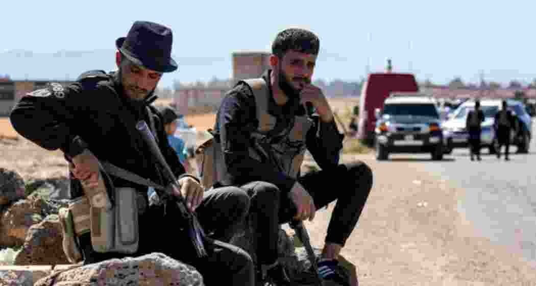 Local faction members in Sweida, Syria, resting on a roadside after the government handed over security control following days of deadly sectarian clashes.