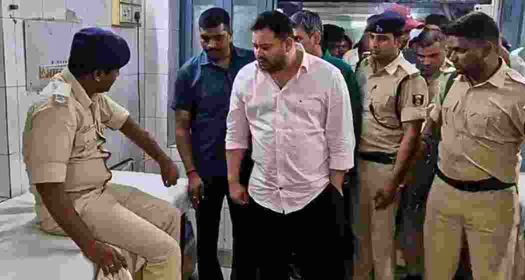 Tejashwi Yadav speaks to an injured security official at a hospital in Vaishali, after a speeding truck struck his convoy during a brief halt for tea near Goraul at midnight on Saturday.