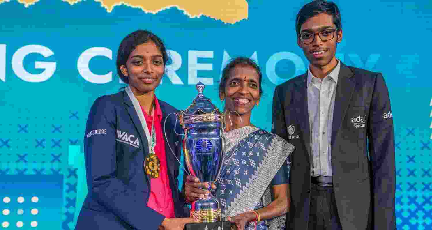 India's GM Vaishali Rameshbabu with her mother and brother R Praggnanandhaa, also a grandmaster, poses for pictures after winning the FIDE Women's Grand Swiss 2025, in Samarkand, Uzbekistan. 