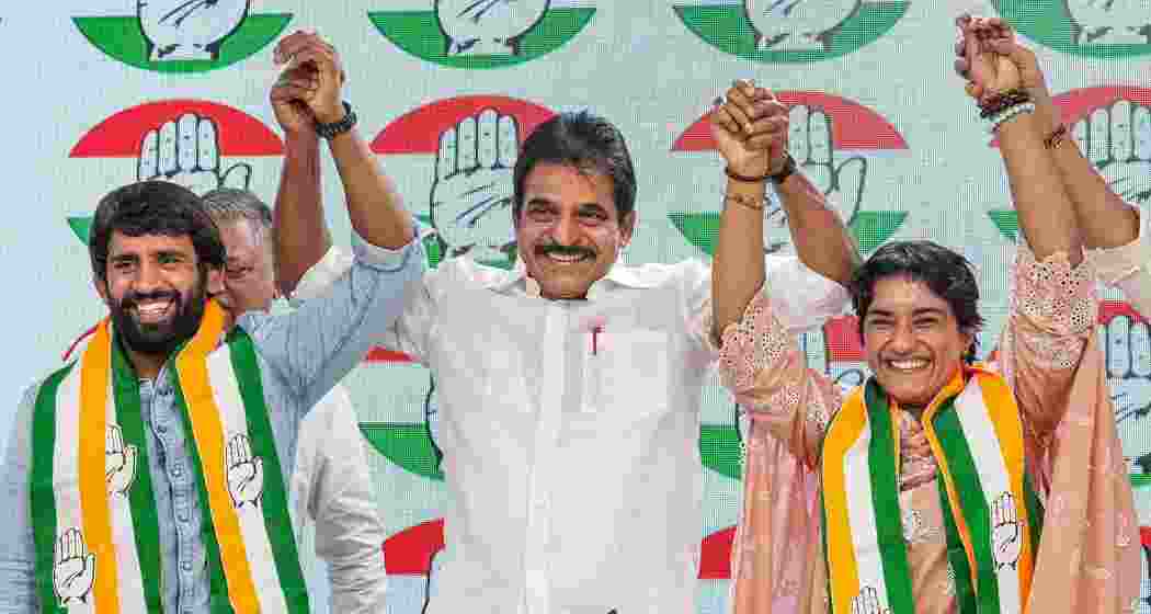 AICC General Secretary KC Venugopal with wrestlers Vinesh Phogat and Bajrang Punia as they joined Congress at the party headquarters, in New Delhi, Friday