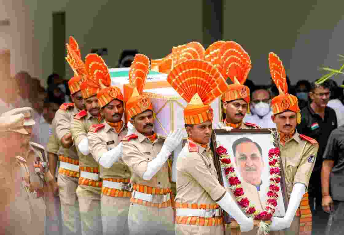 Police personnel carry the mortal remains of former Gujarat chief minister Vijay Rupani for a wreath-laying ceremony in Ahmedabad after the Air India AI171 crash that killed 260 people on June 12, 2025. File photo.