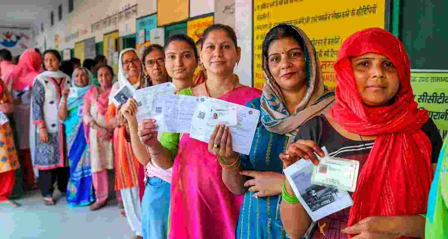 Women line up outside a polling station during the Lok Sabha elections 2024.