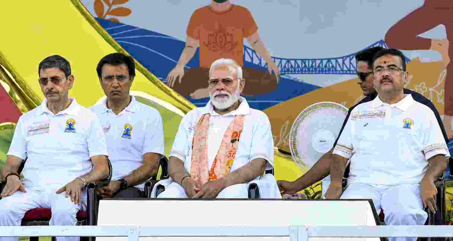 Prime Minister Narendra Modi, West Bengal Chief Minister Suvendu Adhikari and Governor RN Ravi during the 12th International Day of Yoga celebrations, in Kolkata.