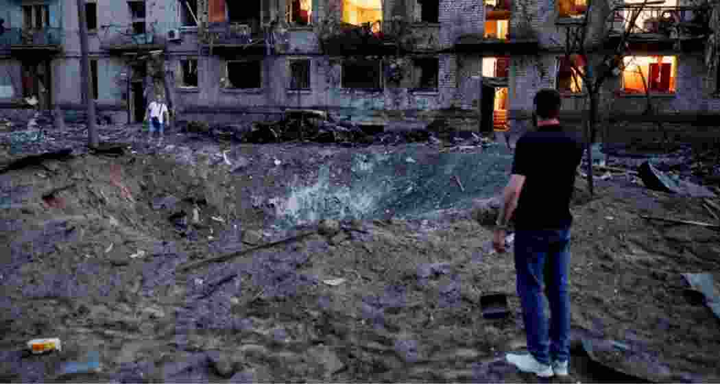 Explosions formed a crater next to bombed-out buildings in Kyiv.
