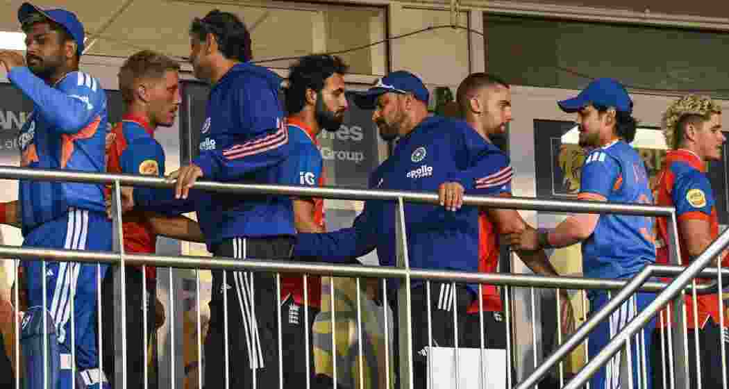 India and England players shake hands as they move between dressing rooms after their first T20I match was abandoned due to rain.