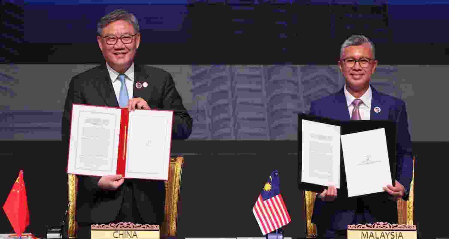 Malaysia Trade Minister and ASEAN Economic Minister Chairman, Tengku Zafrul Aziz and Chinese Commerce Minister Wang Wentao show agreement documents after signing of the ASEAN-China Free Trade Area 3.0 Upgrade ahead of the 28th ASEAN–China Summit, held as part of the 47th ASEAN Summit.