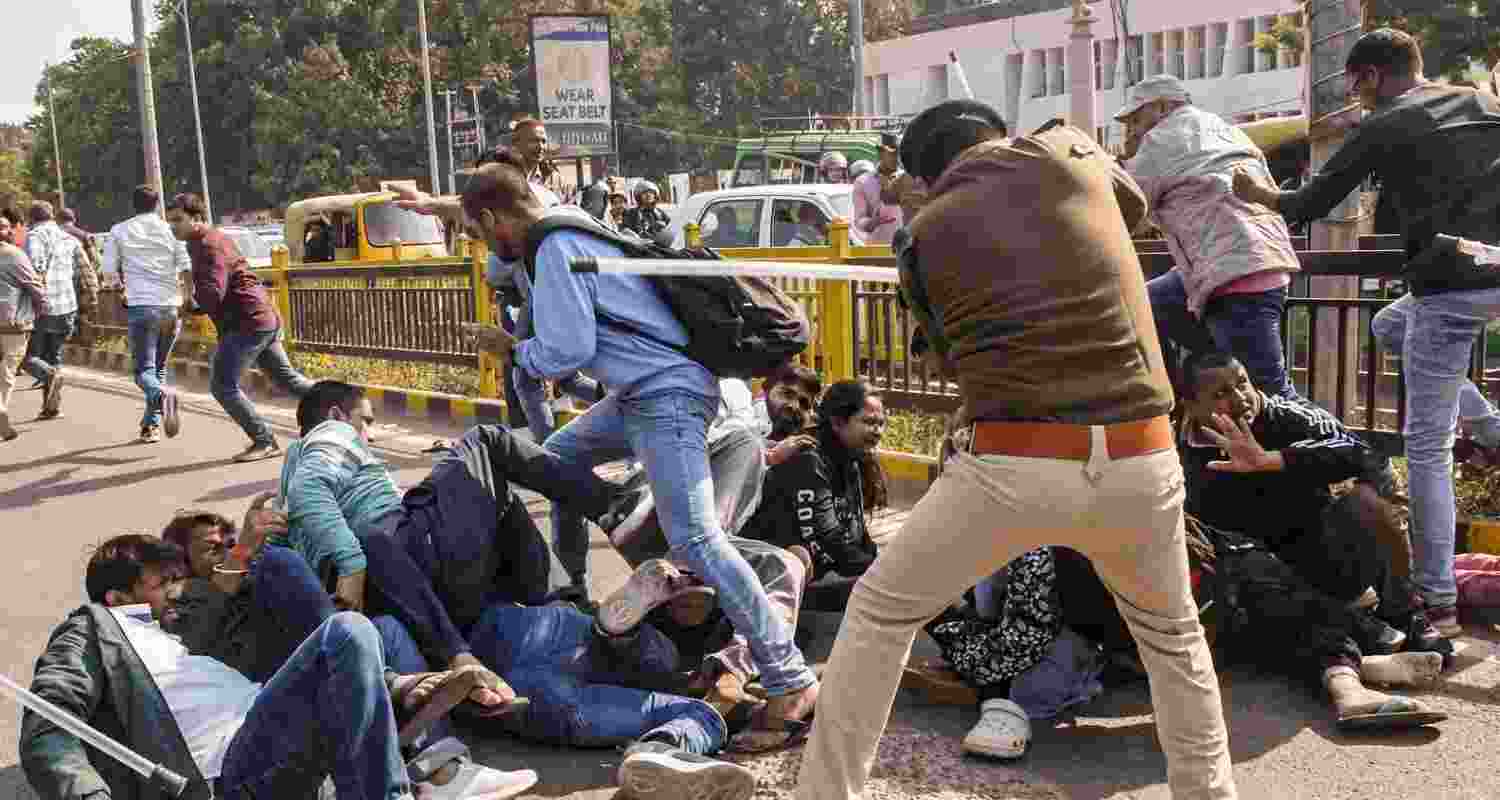 A policeman lathi-charges protesting students in Patna. File photo.